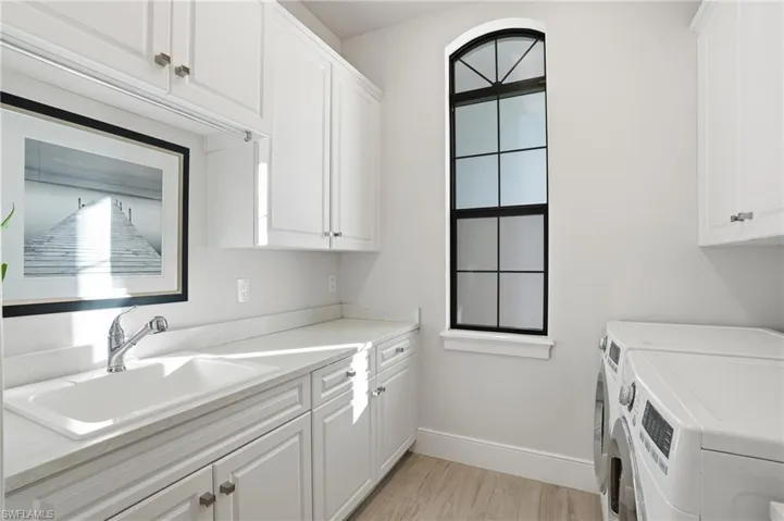 The utility room features plenty of storage space, sink, washer and dryer