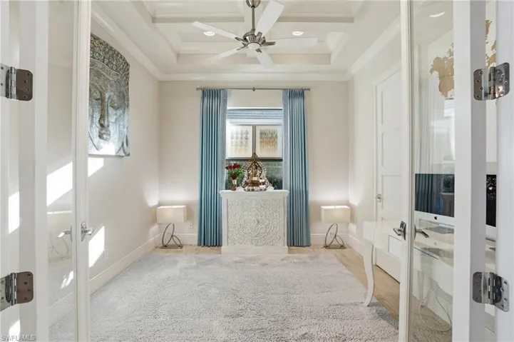 This spacious den offers privacy with glass french doors and coffered ceiling with access to the jack and jill bath