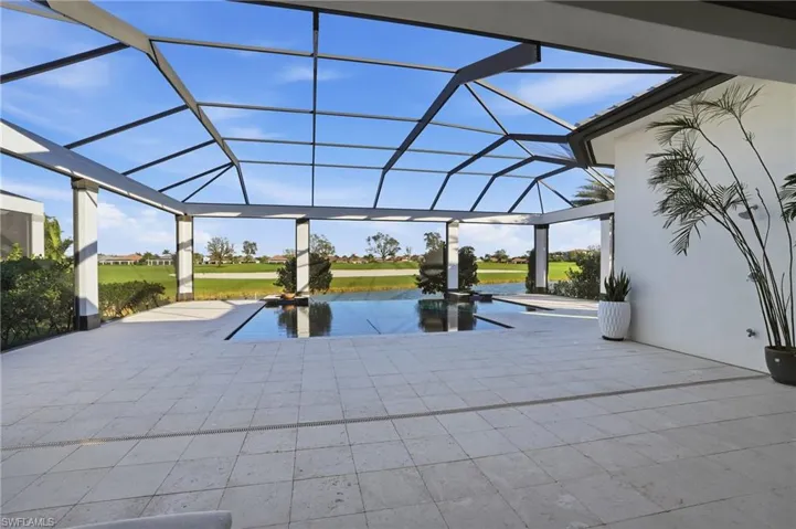 This large pool/spa combo features an infinity edge and water feature bowls, plus an outdoor shower