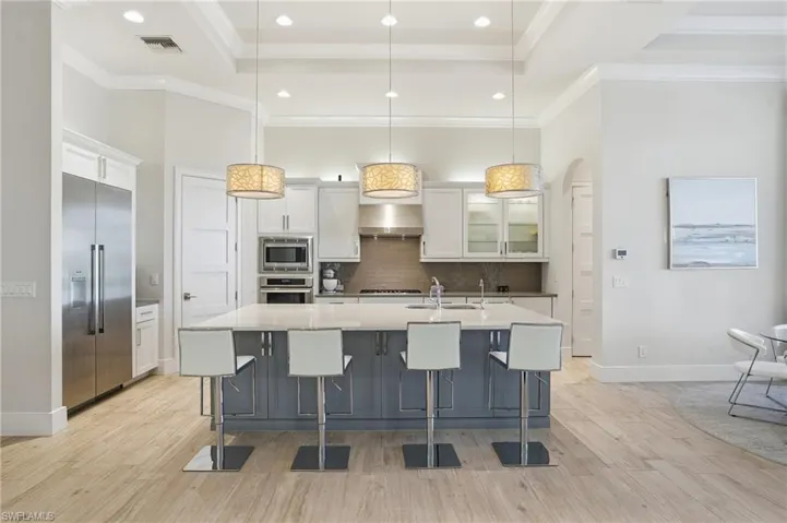 This custom kitchen features a spacious island, custom cabinetry and a pantry