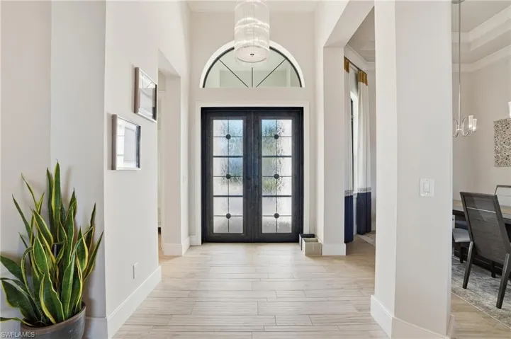 Beautiful light streams through the custom glass and wrought iron door at the entry