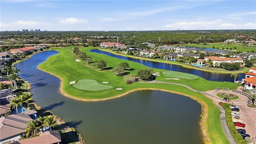 Aerial view of residential area with a golf course and a nearby body of water