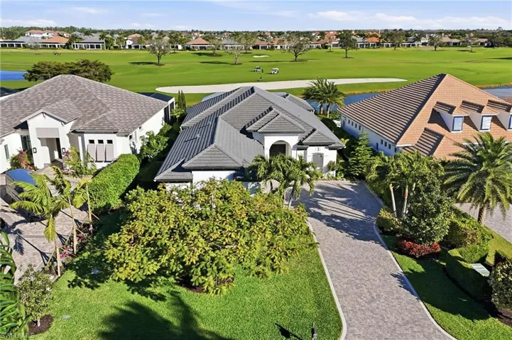Aerial perspective of suburban area featuring a nearby body of water and a golf club
