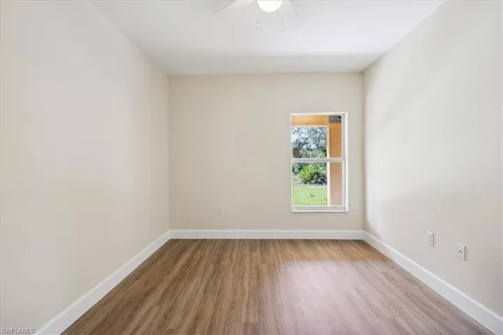Unfurnished room with ceiling fan and hardwood / wood-style flooring