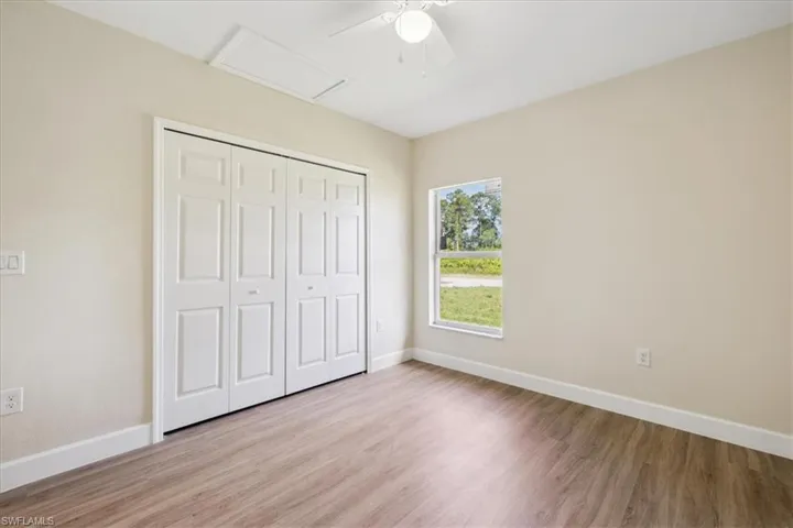Unfurnished bedroom with ceiling fan, hardwood / wood-style flooring, and a closet