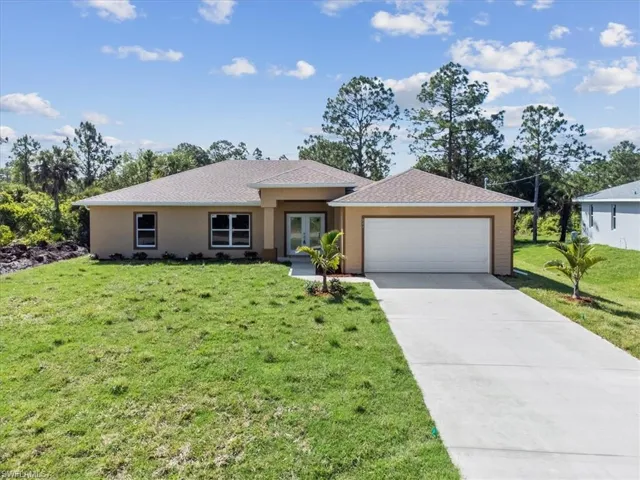 Ranch-style home with a garage and a front lawn