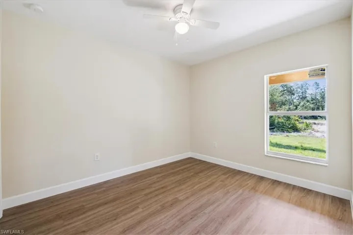 Unfurnished room with ceiling fan and wood-type flooring