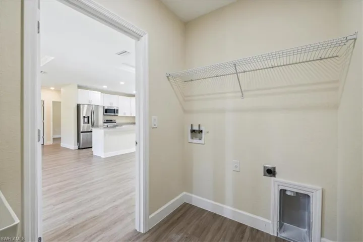 Laundry room with light hardwood / wood-style flooring, hookup for an electric dryer, and washer hookup