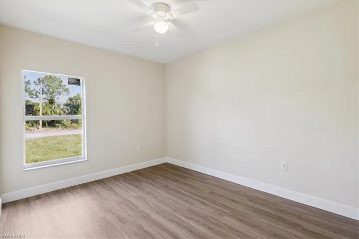 Empty room with hardwood / wood-style floors and ceiling fan