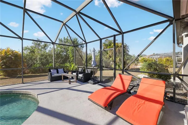 Swimming pool featuring glass enclosure, a sunroom, and a patio