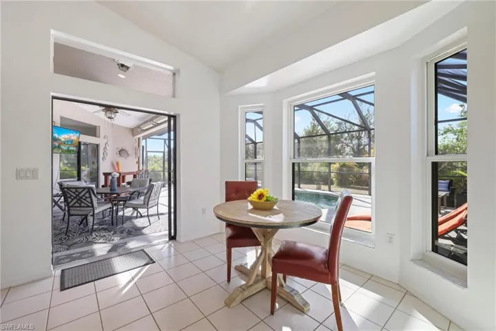 Dining space featuring a sunroom, vaulted ceiling, and light tile patterned floors