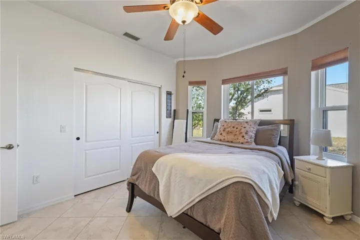 Bedroom with a ceiling fan, a closet, and crown molding