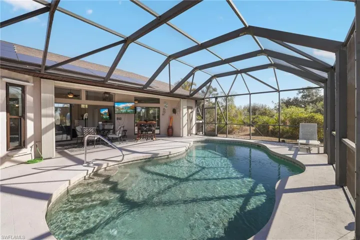 Swimming pool featuring a lanai, a sunroom, a patio area, and outdoor dining area
