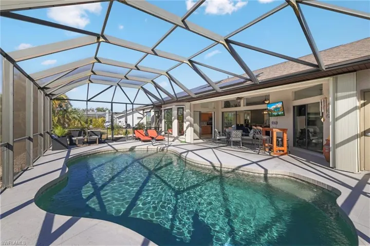 Outdoor pool with a lanai, a sunroom, a patio, and outdoor dining area