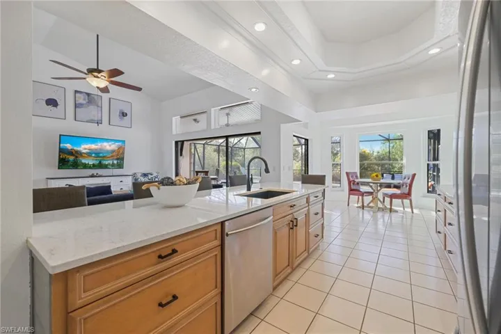 Kitchen with open floor plan, light stone countertops, appliances with stainless steel finishes, healthy amount of natural light, and recessed lighting