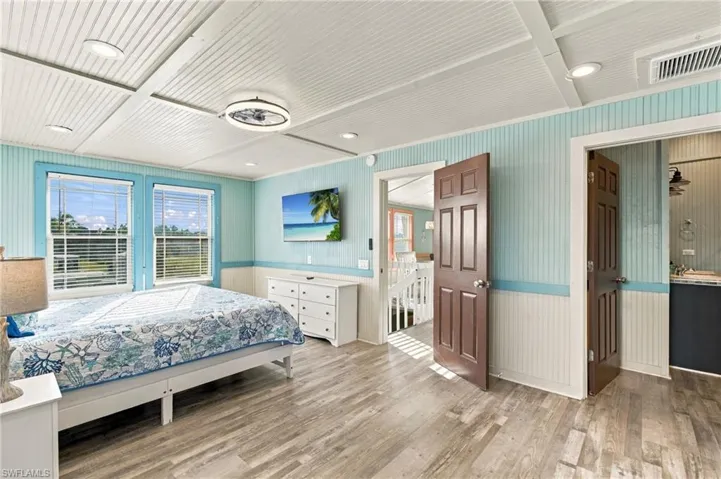 Beadboard wall paneling with chair rail, wood-finish flooring, paneled ceiling, recessed lighting, and six-panel doors - Virtually Edited Image