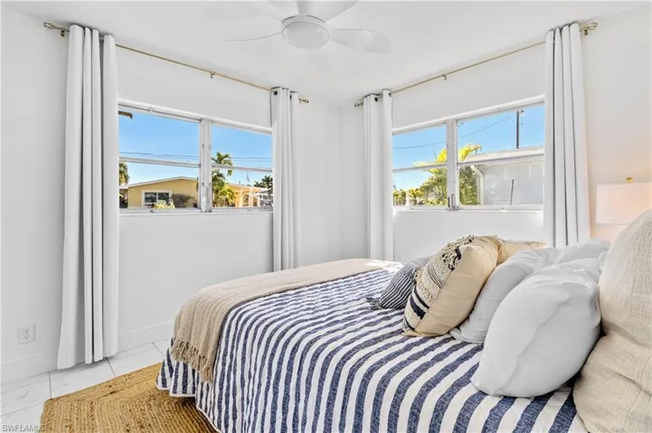 Bedroom featuring a ceiling fan and multiple windows