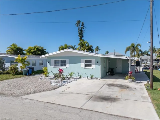 Ranch-style home with stucco siding, driveway, and an attached carport