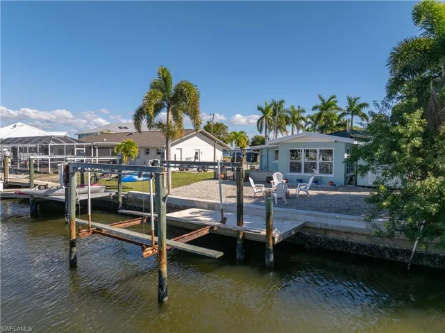 Dock area featuring boat lift, a water view, and a residential view