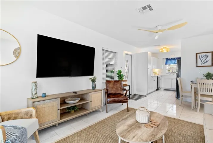 Living area with ceiling fan and light tile patterned flooring