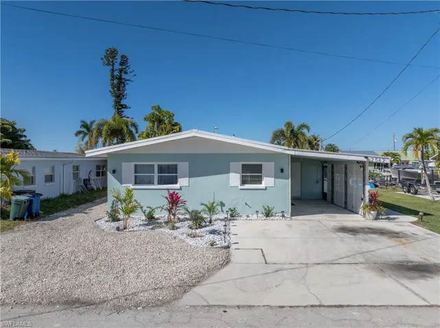 Single story home with a carport, stucco siding, and driveway
