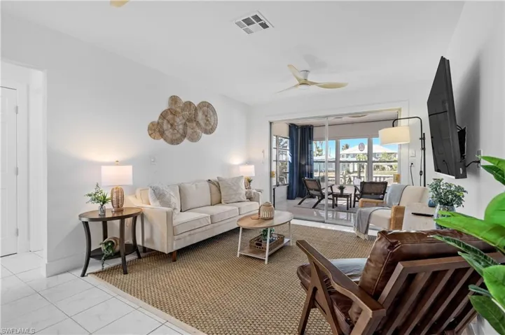 Living room with a ceiling fan and marble look tile flooring