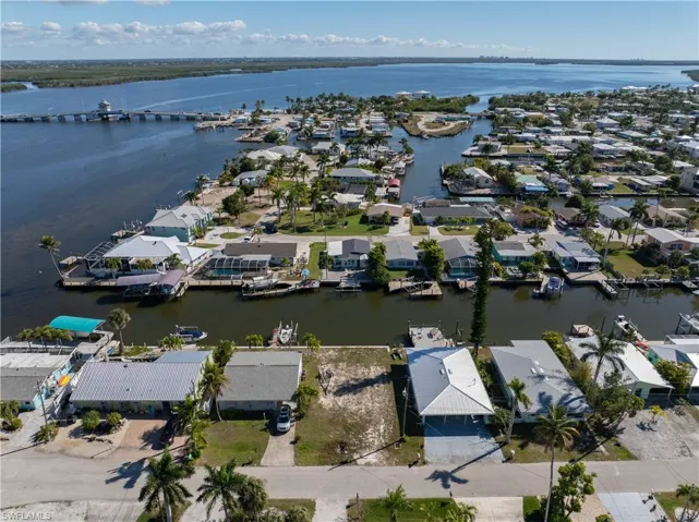 Aerial view of property and surrounding area with a large body of water and nearby suburban area