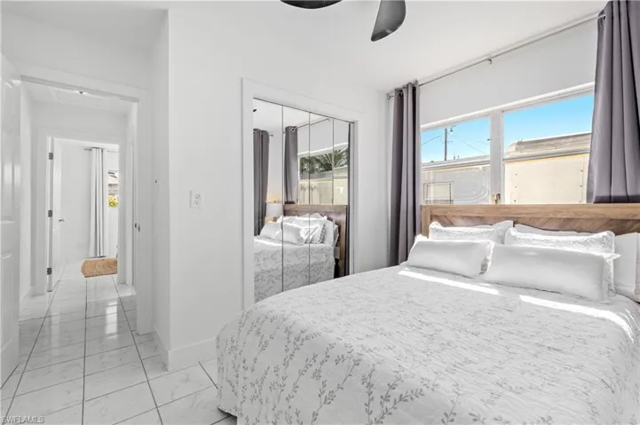 Bedroom featuring a closet, light marble finish flooring, and a ceiling fan