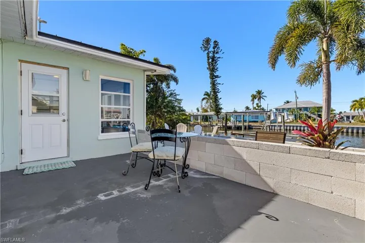 View of patio with a water view, boat lift, and a boat dock
