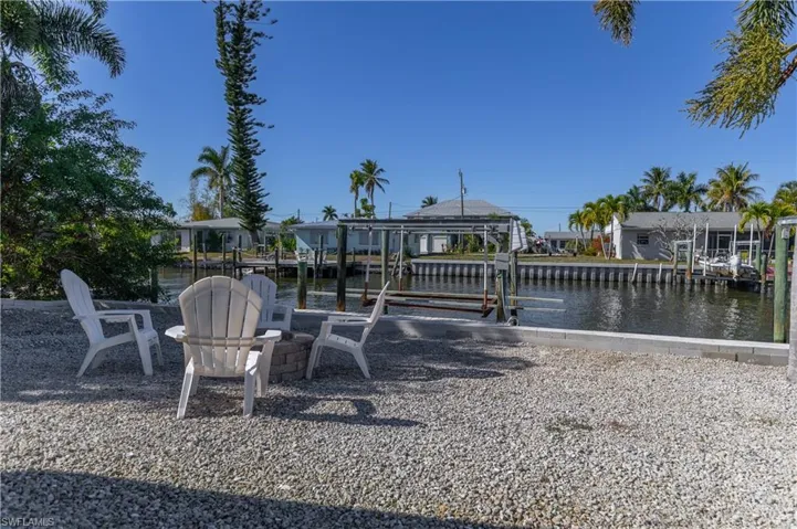Dock with boat lift, a water view, and a residential view