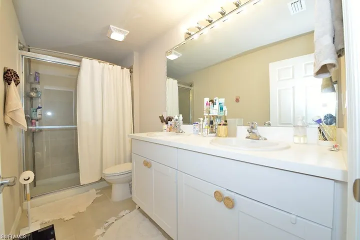 Bathroom featuring tile patterned flooring, vanity, and toilet