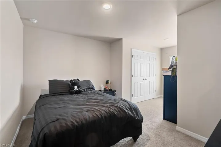 Carpeted bedroom featuring a closet