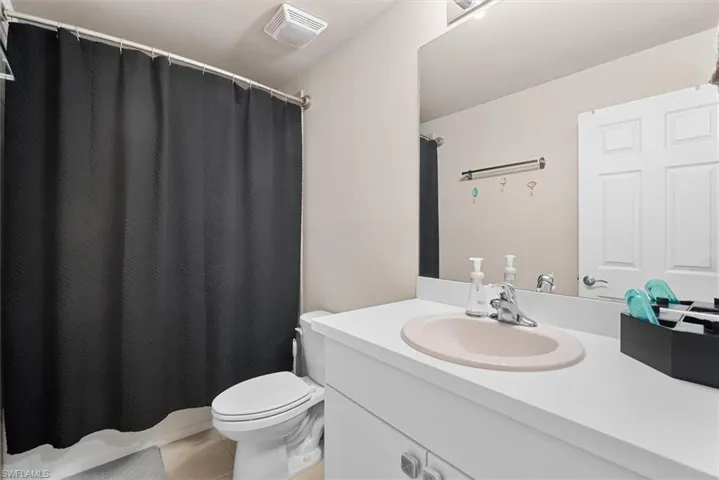 Bathroom featuring tile patterned flooring, vanity, and toilet