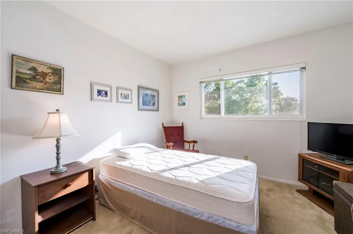 Bedroom featuring light carpet