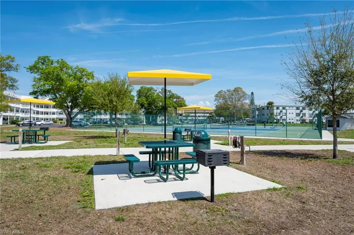 View of community with a lawn and tennis court