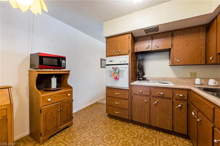 Kitchen featuring a textured ceiling, sink, and white appliances