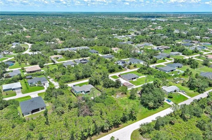 Aerial view of property and surrounding area with nearby suburban area