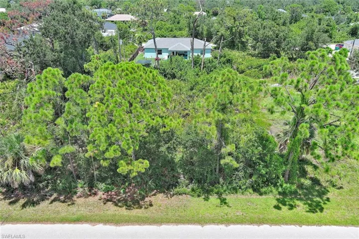 Aerial view of property and surrounding area featuring a forest