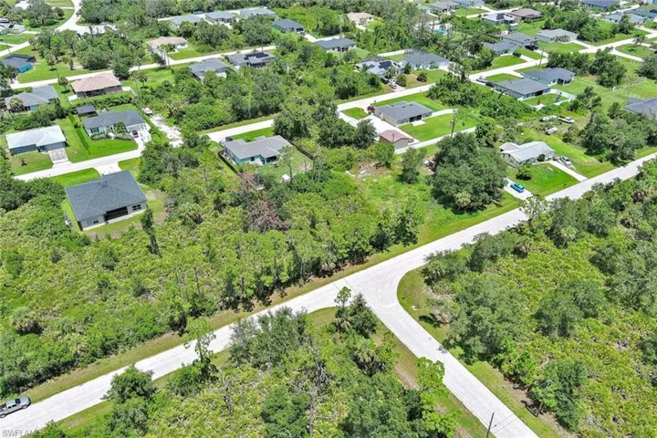 View of property location with nearby suburban area and a tree filled landscape