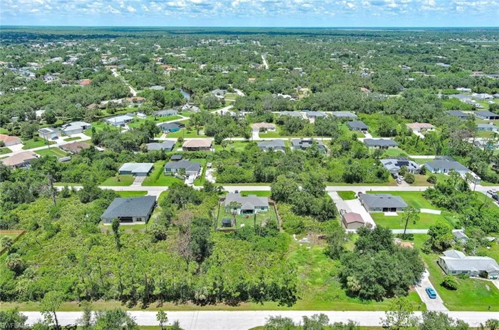 Aerial view of property and surrounding area with nearby suburban area