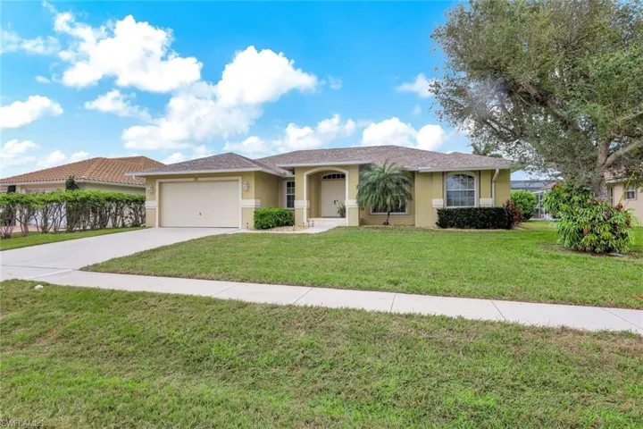 View of front of property with a garage and a front lawn