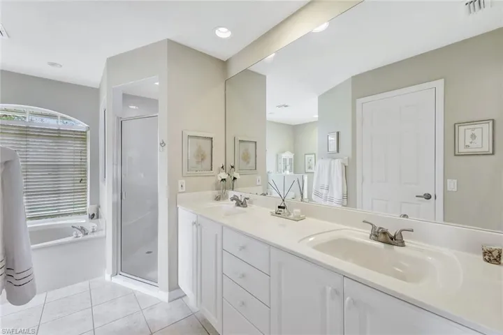 Bathroom featuring vanity, tile patterned flooring, and independent shower and bath