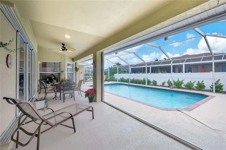 View of pool with ceiling fan, a lanai, and a patio
