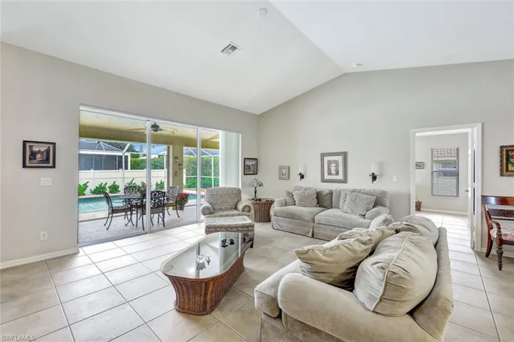 Living room with light tile patterned floors and vaulted ceiling