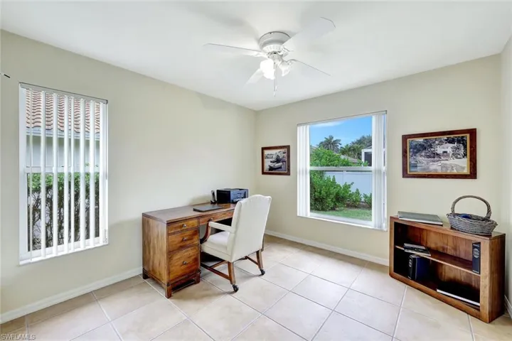 Tiled office featuring ceiling fan and a wealth of natural light