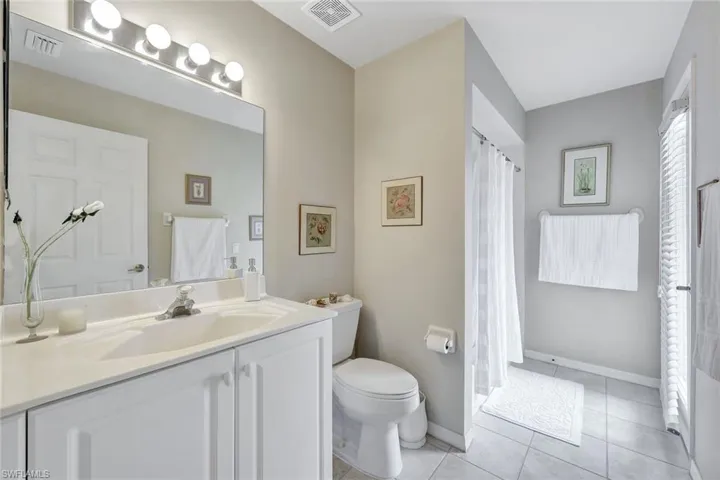 Bathroom with toilet, vanity, and tile patterned flooring