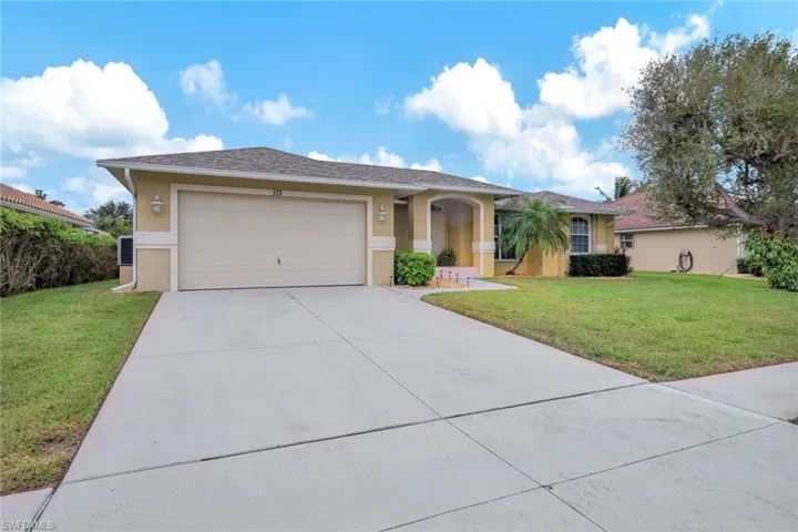 Single story home with a garage and a front lawn