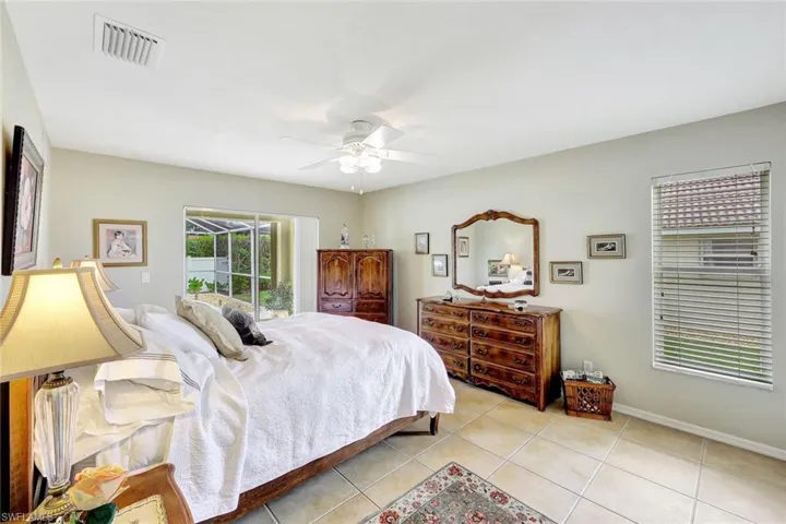Tiled bedroom featuring ceiling fan and access to exterior