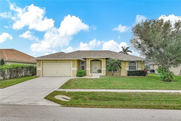 Single story home with a garage and a front yard