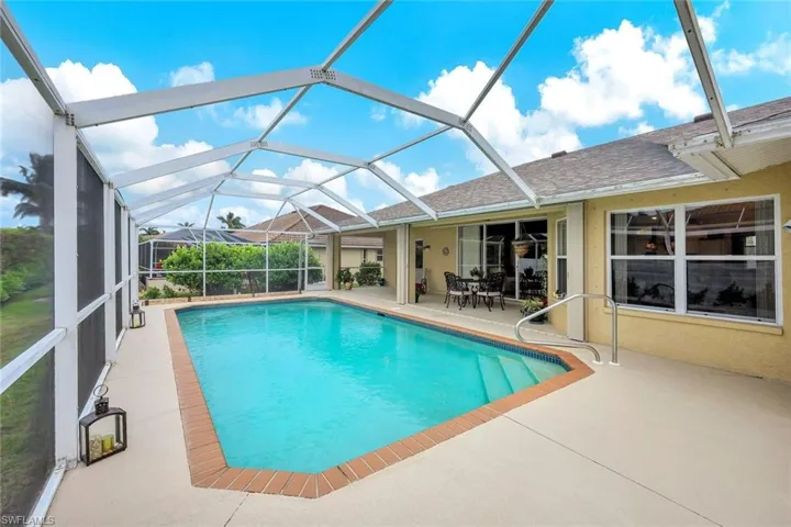 View of swimming pool featuring a patio and glass enclosure